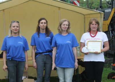 Strażak odbiera certyfikat za zasługi w działalności charytatywnej i pomoc w lokalnych inicjatywach.