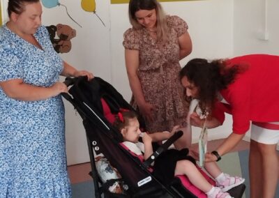 Trzy kobiety z dzieckiem w wózku, tło ozdobione rysunkami misiów i balonów, napis "MISIE".