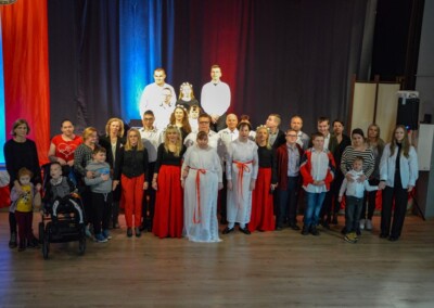 Zdjęcie grupowe uczestników wydarzenia, w tym dzieci, dorośli i osoba na wózku inwalidzkim.