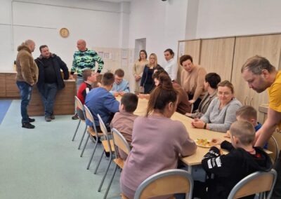 Grupa ludzi zgromadzona wokół stołu w jasnym, nowoczesnym pomieszczeniu.