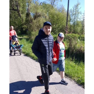 Dwóch mężczyzn idzie trzymając się za ręce, za nimi mężczyzna pcha wózek z dzieckiem.