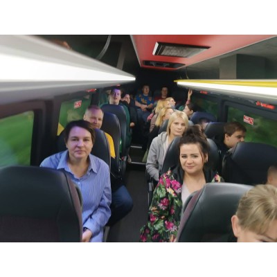 Wnętrze autobusu z pasażerami siedzącymi na fotelach w rzędach.