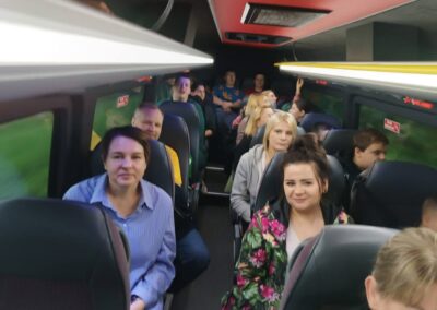 Wnętrze autobusu z pasażerami siedzącymi na fotelach w rzędach.