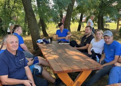 Uczestnicy idą razem w kolumnie podczas marszu; widać sportowe ubrania, plecaki i spokojne tempo.