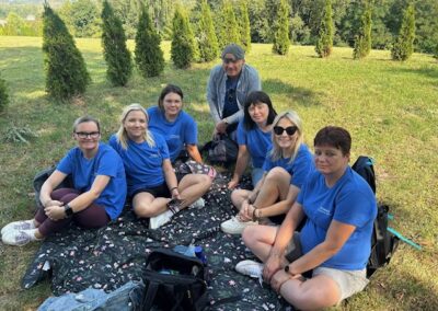 Kilka osób w grupie rozmawia i idzie dalej trasą wydarzenia na zewnątrz; w tle pozostali uczestnicy.