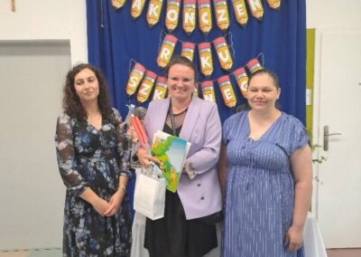 Nauczyciele pozują do zdjęcia z bukietem kwiatów po uroczystości zakończenia roku przedszkolnego.