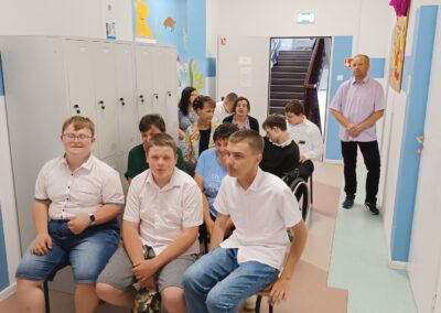 Uczniowie siedzą na widowni i uważnie obserwują przebieg zakończenia roku szkolnego.