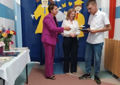 Moment przekazania dokumentów uczniowi w trakcie oficjalnej części wydarzenia.