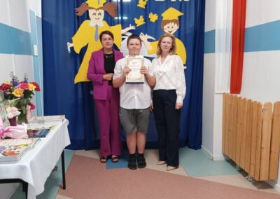 Nauczycielka składa gratulacje uczniowi po wręczeniu dyplomu.