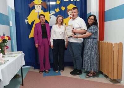 Kolejny uczeń odbiera dyplom podczas zakończenia roku szkolnego.