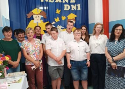 Uczestnicy stoją przed dekoracją w trakcie oficjalnej części wydarzenia.