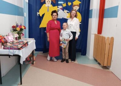 Nauczycielka wręcza dyplom podczas ostatnich momentów wydarzenia.