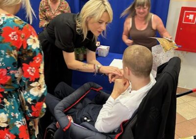 Uczniowie i nauczyciele ustawieni do pamiątkowego zdjęcia na tle dekoracji zakończenia roku.